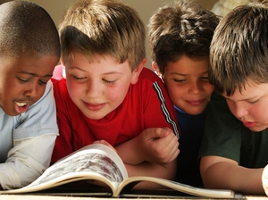 Four schoolboys reading